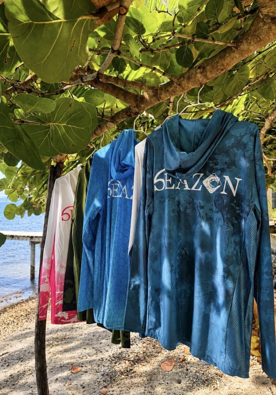 Lycras à capuche Seazon suspendus à un arbre au bord du lagon